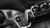 Automatic gear selector with P R N D M +/- indicators in a car interior.