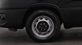 Side view of a black van with a steel-wheel tire visible at the front wheel well