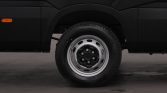 Close-up of a black vehicle's wheel: a silver steel rim with a Bridgestone tire inside a wheel arch and black fender.