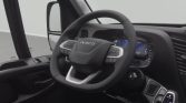 Steering wheel and digital dashboard of an Iveco vehicle interior with gear selector to the right and side door controls nearby