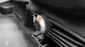 Close-up of a car seat adjustment dial with a numbered scale and orange marker indicating position