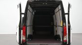 Open white cargo van from the rear with an empty storage space and dark floor