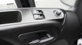 Car interior door panel with window control switches and side mirror adjustment knob on the right side