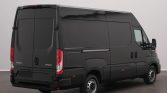Black Iveco Daily cargo van shown from the rear and right side, indoors showroom setting