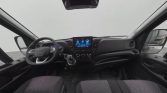 Front interior of a modern van showing steering wheel, center touchscreen, and control panel in view.