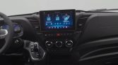 Modern car interior featuring a central touchscreen infotainment system above climate controls and a gear shifter in the foreground.