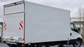 White box truck parked on a paved lot, rear cargo doors closed and reflective red-and-white panels visible on the back doors.