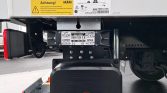 Under the trailer, the DHOLLANDIA lift system with control panel (LIFT, LOWER, OPEN, CLOSE) and warning labels visible.