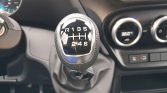 Close-up of a six-speed manual gear knob showing the shift pattern (R, 1–6) in a car interior