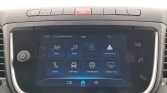 Infotainment touchscreen im Auto mit Symbolen für Radio, Media, Apple CarPlay, Android Auto, Telefon, Fahrzeug, Einstellungen (Bildschirmstart).
