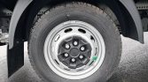 Wheel on a truck with a silver steel rim and black center cap, tire and mudguard visible in background.