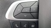 Car steering wheel control cluster with a directional pad and center OK button; bottom row includes phone, voice, and menu buttons for hands-free use.