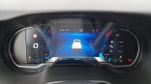 Digital car dashboard with a central screen showing a white pickup on a blue road, speedometer at 0 km/h, left-side gauge, and fuel/engine data on the right; date/time and temperature displayed above.