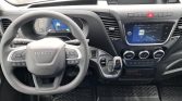 Driver's cockpit of a modern Iveco van with a digital instrument cluster, multifunction steering wheel, and central touchscreen infotainment system in a black dashboard interior