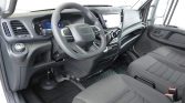 Interior view of a modern van cabin with steering wheel, dashboard, and front seats visible ahead of the driver.