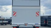 Rear view of a white cargo trailer with two red diagonal reflectors, SAXAS logo, and Dhollandia/Iveco badges on the bumper.