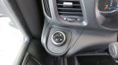 Circular drive-mode/select knob on the lower dashboard with D and M options and up/down arrows, surrounded by settings like LOAD, AUTO, and SOFT near the air vent.