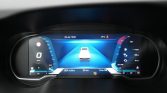Digital car dashboard showing 0 km/h speed, central vehicle graphic, and range/fuel indicators on the sides.