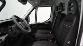 Interior of a white commercial van showing the driver's seat and two passenger seats with black fabric upholstery and headrests
