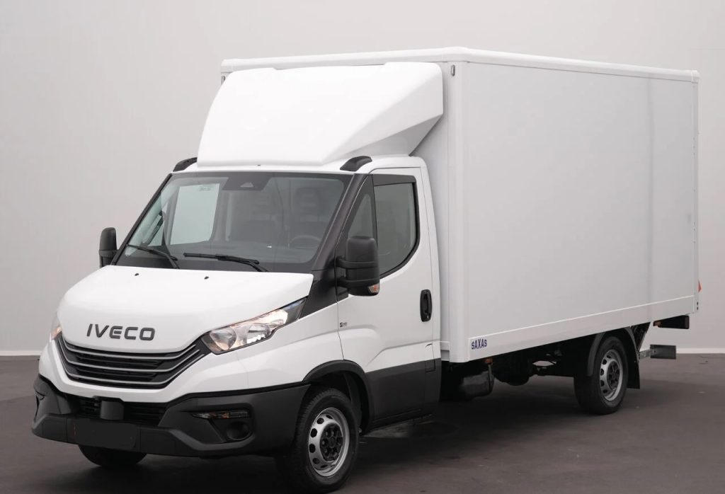 White Iveco delivery truck with a large enclosed cargo box, parked indoors.