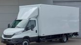 White Iveco box truck with a large cargo box parked near a gray industrial building, showing the cab and front end clearly.
