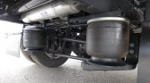 underside of a truck showing large air suspension bags and drivetrain components in view