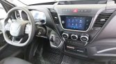Interior of a vehicle cockpit showing a steering wheel, dashboard touchscreen, and center controls on the right side of the cabin.