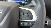 Steering wheel close-up showing cruise control buttons (SET+, SET−, CANCEL, RES) on the right side with a silver trim, textured black surface, and a partial dashboard in the background.