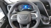 Steering wheel of a modern Iveco vehicle with digital instrument cluster in the background and control buttons on the spokes