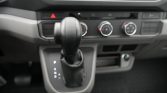 Close-up of a car’s center console with an automatic gear shifter and climate control knobs in the background.