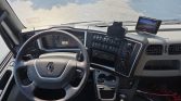 Driver's cockpit of a Renault truck with steering wheel, dashboard, and mounted screen on the right side of the dash