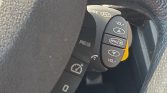 Steering wheel stalk with control buttons: VOL+ at top, VOL- at bottom, a MENU/OK button in the middle, and left/right arrows visible.
