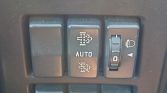 Car dashboard switches: left blank button, middle AUTO with light symbols, right headlight level dial with 0/1 marks.