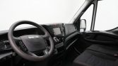 Interior of a van cabin showing steering wheel with Iveco logo, center touchscreen, and front seats