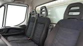 Interior of a white van showing three black fabric seats with headrests and seat belts in the front cabin area