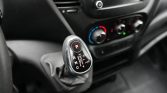 Close-up of a modern car gear shifter in Park, with climate control dials blurred in the background on the center console.