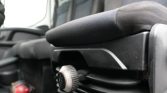 Close-up of a car seat adjustment knob on black upholstery inside a vehicle interior.