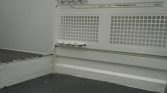 White truck bed with a perforated metal tailgate/partition and a ribbed side wall, showing a worn industrial milky finish.