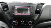 Car dashboard center console with a touchscreen infotainment system displaying FM radio settings in a vehicle interior