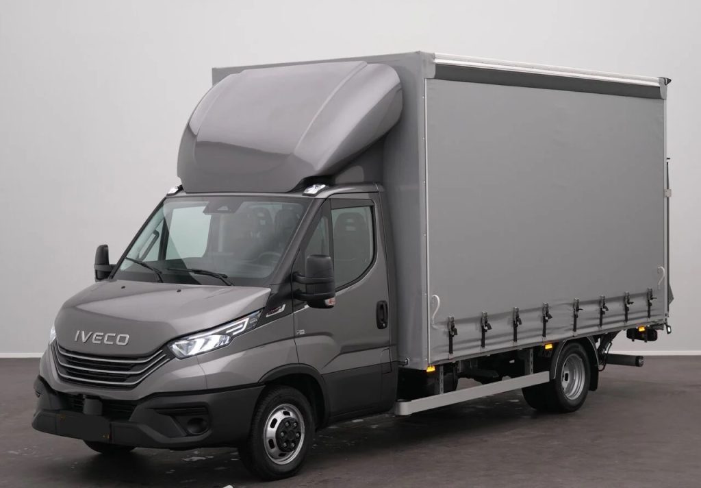 Gray Iveco delivery truck with a tall gray cargo box and raised cab, parked indoors.