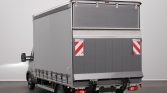 Grey box truck viewed from the rear-right, showing the closed cargo area and reflective warning panels on the back doors.