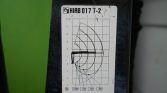 Label on a mechanical arm showing a radius/load chart with curved arcs and measurement grid (HIAB 017 T-2) for lift capacity by reach and height.