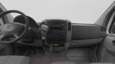Front interior of a Mercedes van showing the steering wheel, center console, and gear shift.