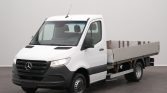 White Mercedes-Benz flatbed cargo truck photographed indoors, angled to show the cab and metal cargo bed behind it.] (Note: this line shouldn't be included)