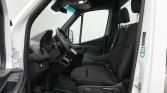 Interior of a white van showing the driver and front passenger seats, steering wheel, and dashboard