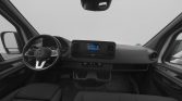 Interior view of a modern van cabin showing a steering wheel, central touchscreen, and two front seats with a clean dashboard.