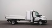 White utility truck with an open flatbed, parked indoors on a plain floor.
