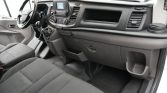 Interior view of a van's front cabin showing steering wheel, center console, and front seats