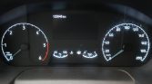 Close-up of a car's dashboard gauge cluster: tachometer on the left, speedometer on the right, central display shows 122,848 km with small fuel and temperature gauges below.