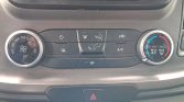 Car climate control panel: left circular fan speed dial, central row of control buttons (defrost, airflow, recirc, A/C), and right temperature dial with blue/red zones.